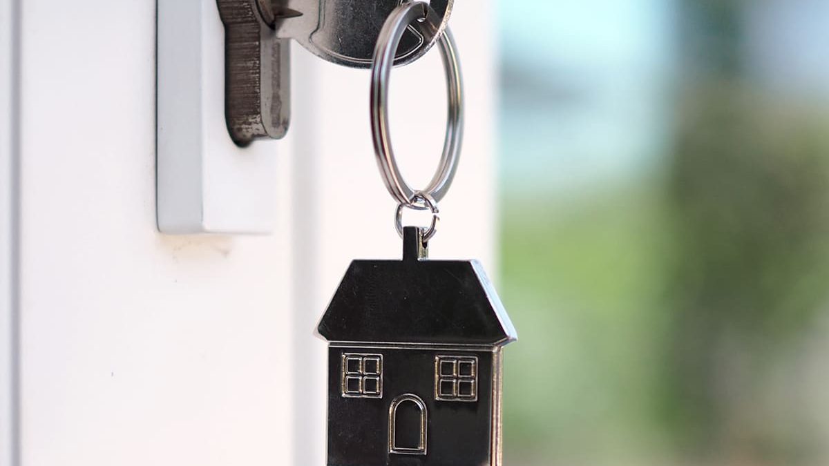 Chave com chaveiro de casa na fechadura da porta